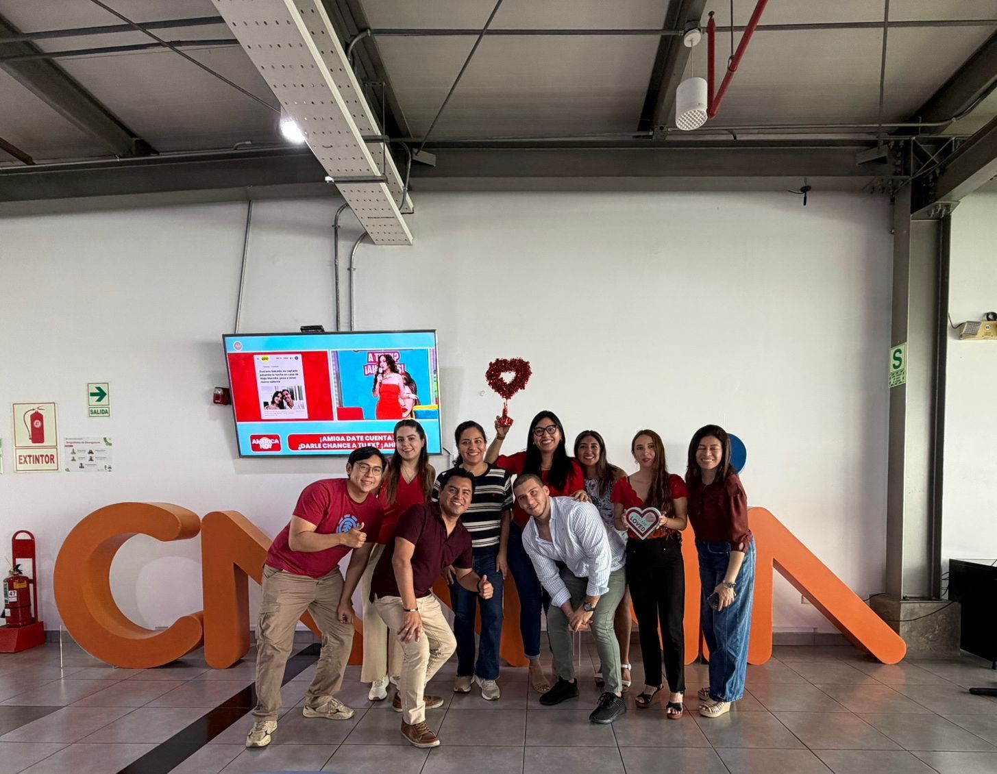 Equipo reunido frente al letrero de la oficina